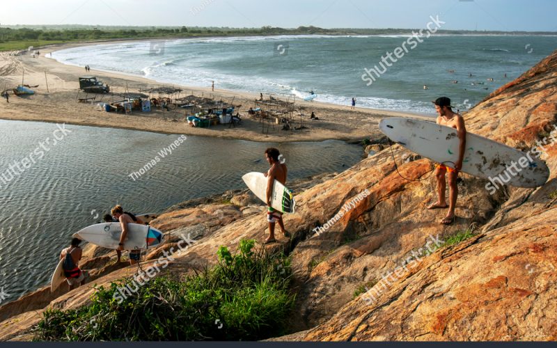 stock-photo-arugam-bay-sri-lanka-august-a-group-of-surfers-climb-down-elephant-rock-towards-the-1492815632